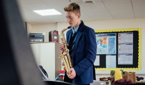 Enfant en train d'apprendre à jouer du saxophone